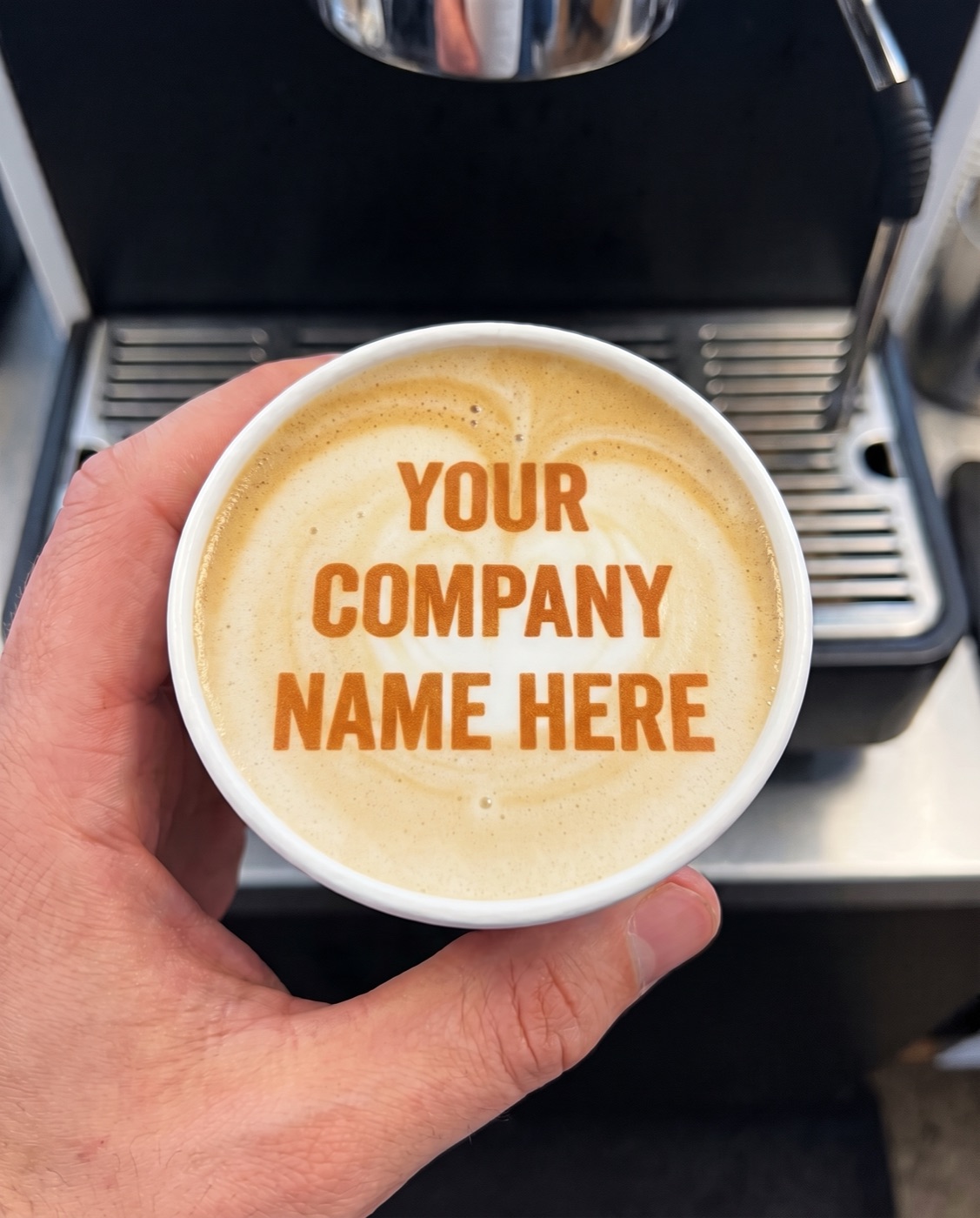 Custom branded latte with a company name printed on the foam