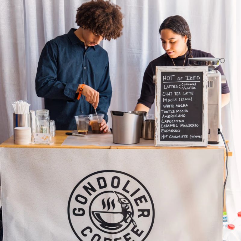 Two Gondolier Coffee baristas serving handcrafted coffee at a Twin Cities event